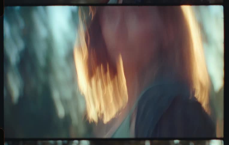 A woman with a camera in her face pointing forward and then she takes the camera away from her face