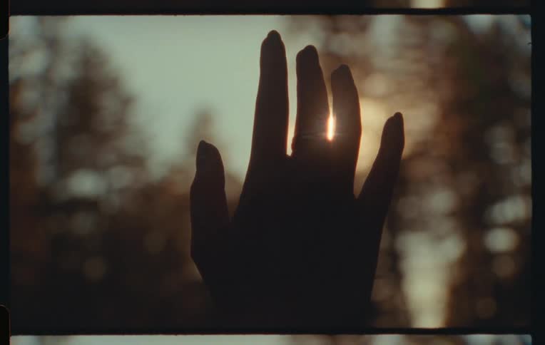 Hand with a ring against the reflection in the sun