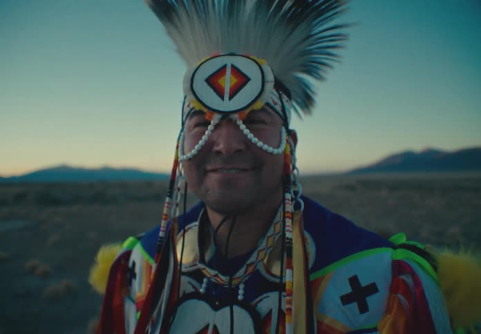 Happy man wearing a traditional mask in a field