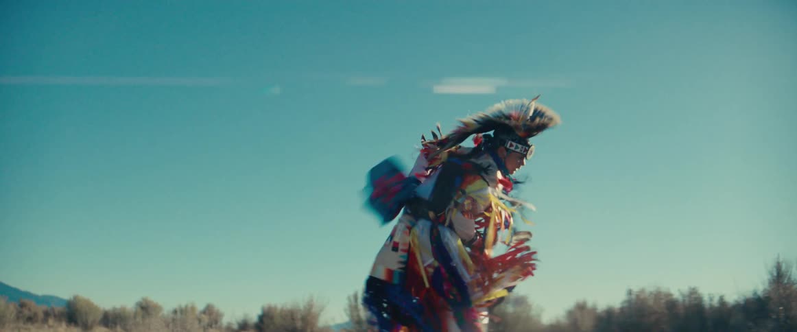 Native american man in costume dancing in a field