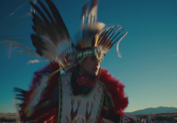 Native american man dancing in colorful costume in natural setting