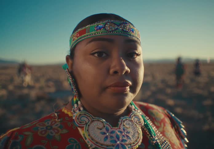 Young woman in a desert field wearing native american attire