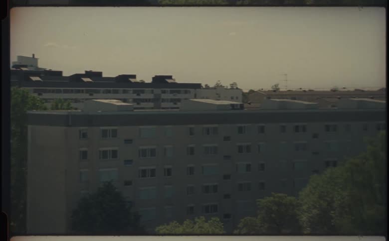Groves of trees border apartment buildings on a hazy day