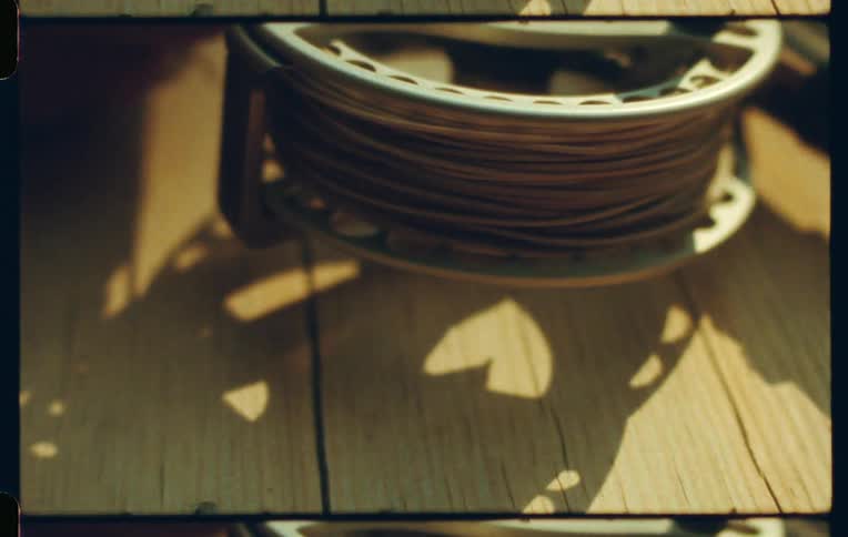 Fishing flies and a fishing reel on a wooden surface