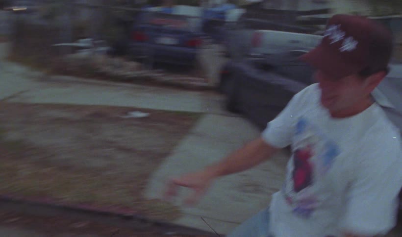 A man runs down the street and jumps into the passenger seat of a convertible