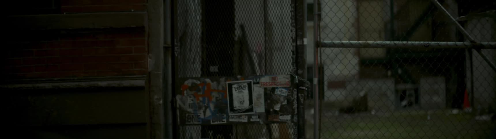 A chain link fence stands in a city