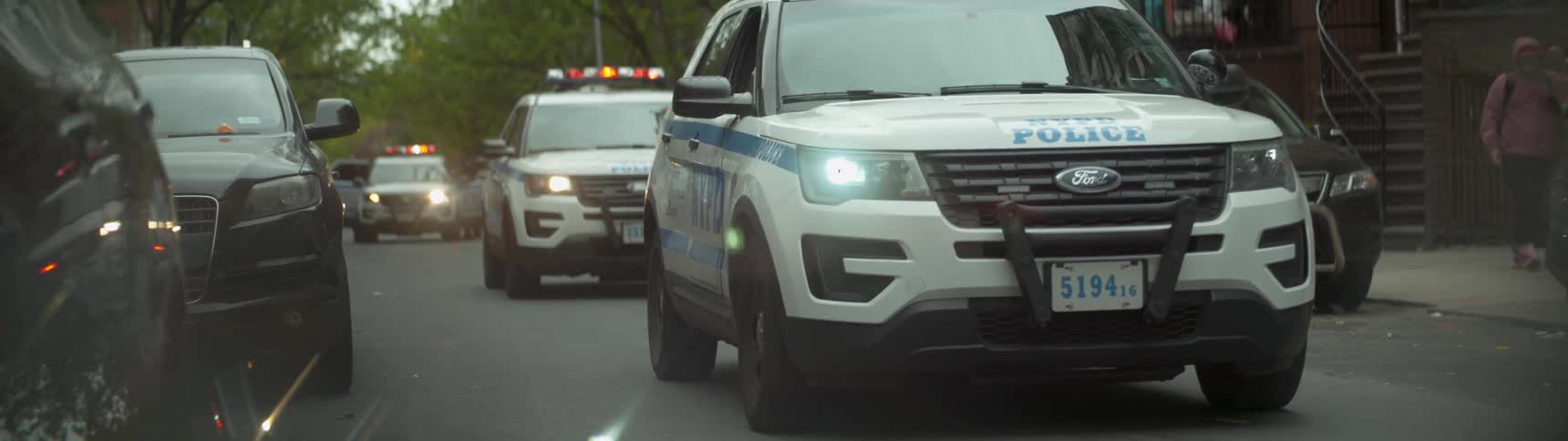 Lights on police cars flash while parked on a city street