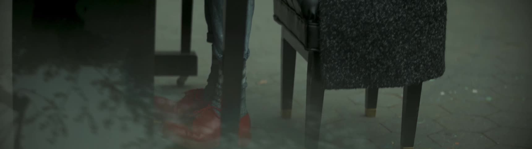 A woman wearing red shoes sits at a piano