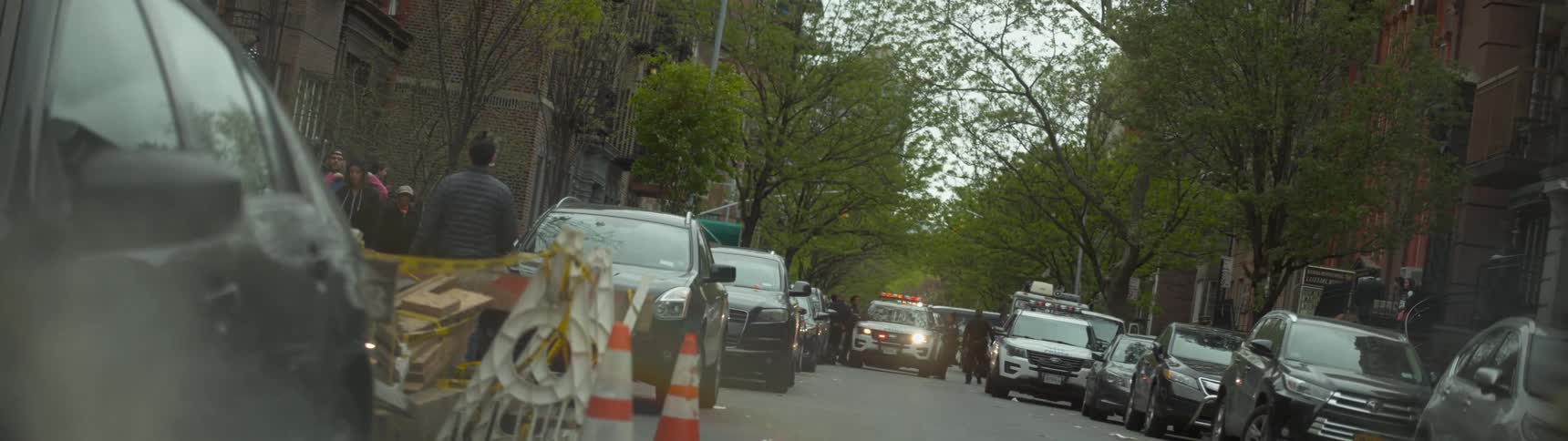 A view of a city street filled with cars , trees, and buildings