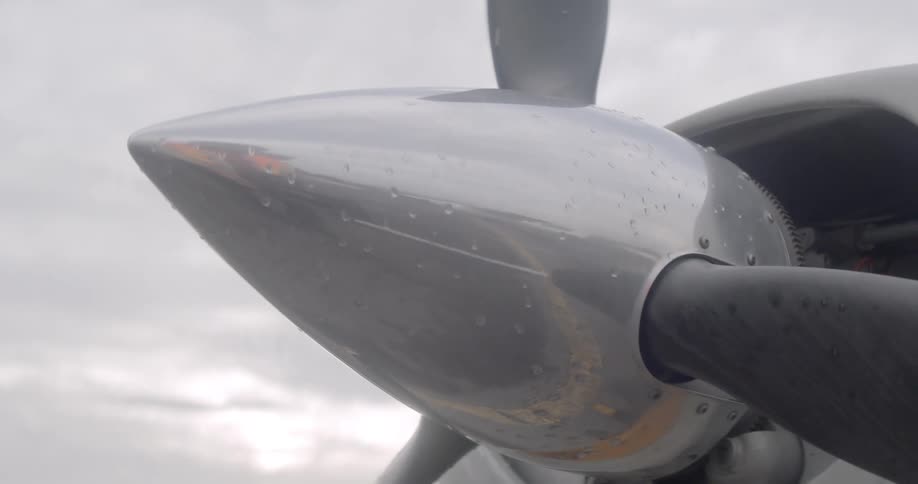 A person is reflecting on the propeller as he walks past