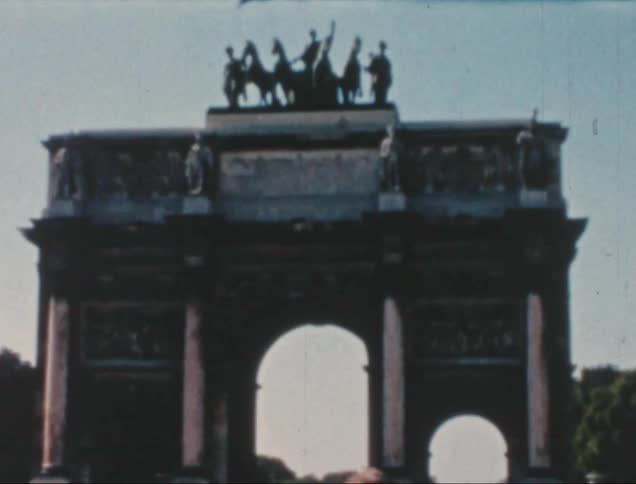 Sightseers looking at sculptures on top an arch