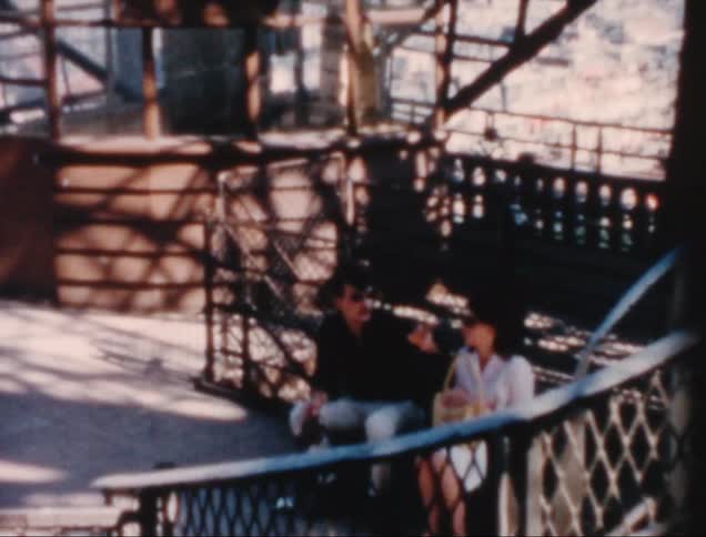 Man and woman sitting on a bench on a metal structure