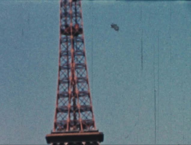 View of the eiffel tower focusing on its intricate latticework and the people on its observation deck