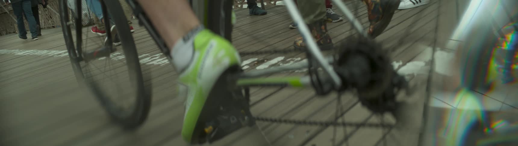 A person riding a bicycle and it shows a close up of their feet and is in slow motion