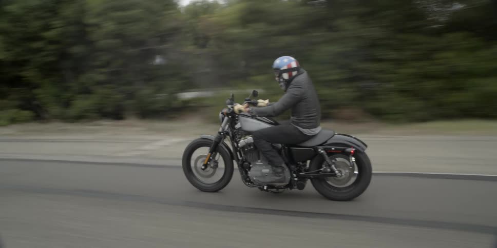 A man riding a motorcycle down a country road