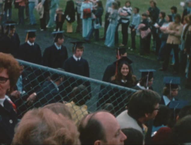 Graduates walk in a line outside