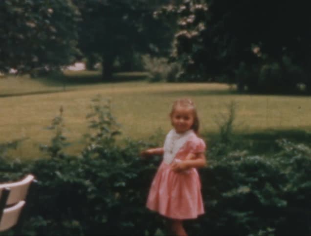 Little girl in a pink dress in a garden