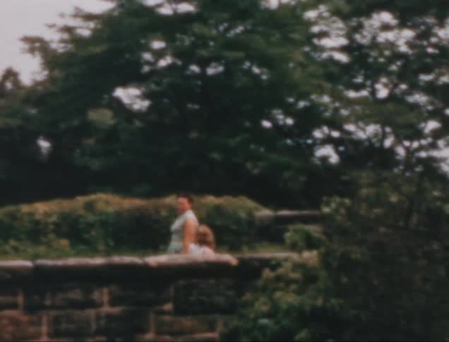 A footage of a mother and daughter walking along the garden