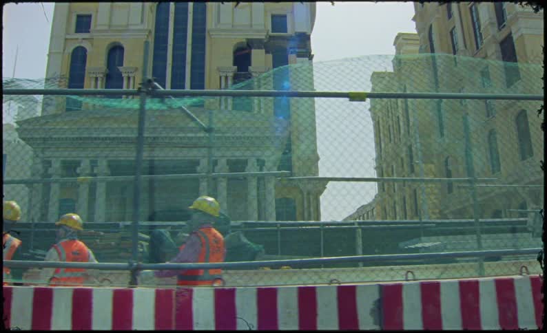 Workers wearing protective vests and helmets at a construction site