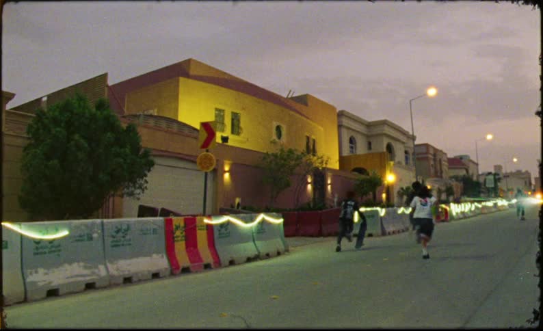 Children running and skateboarding down a street