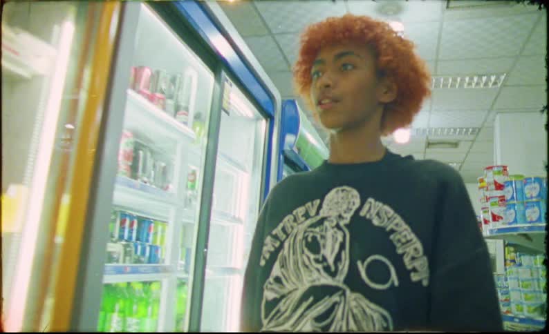 A group of teenagers walking through a grocery store