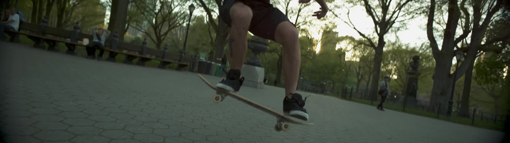 A man doing flips on a skateboard in a city park