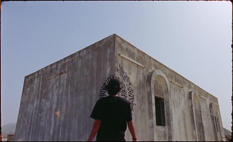 Man in cap appreciating art on a wall