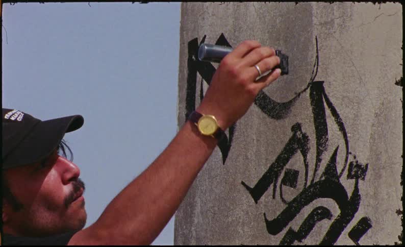 A man is using painting graffiti on the wall