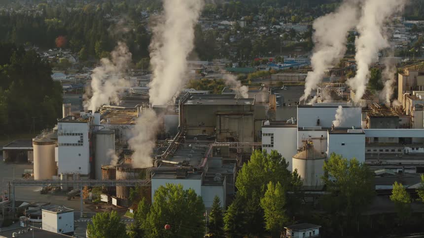 Smoke rises from a factory on the edge of town