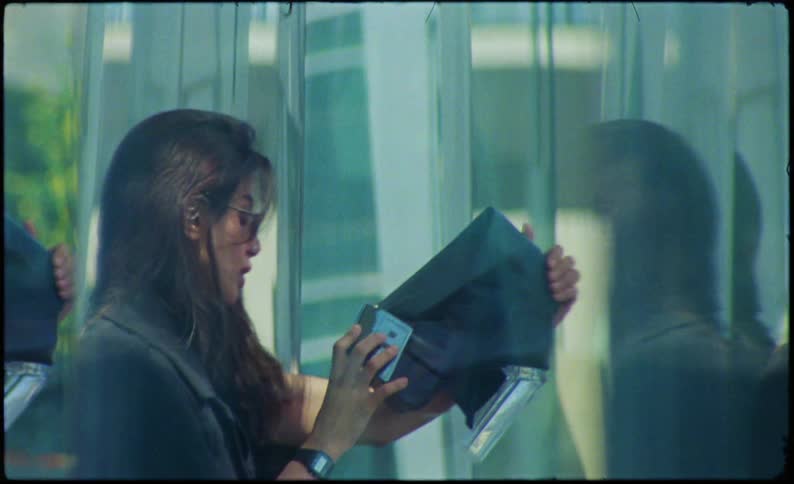 Reflection of a woman wearing glasses looking at a black leather boot