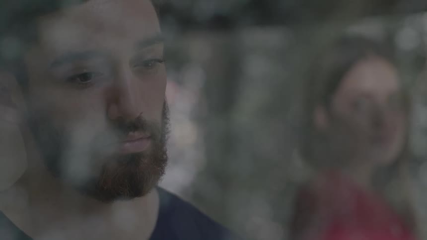 Man with a dejected look and a woman in the background