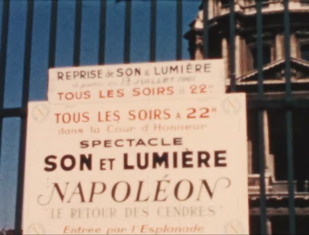 A sign is on the gate in front of the building