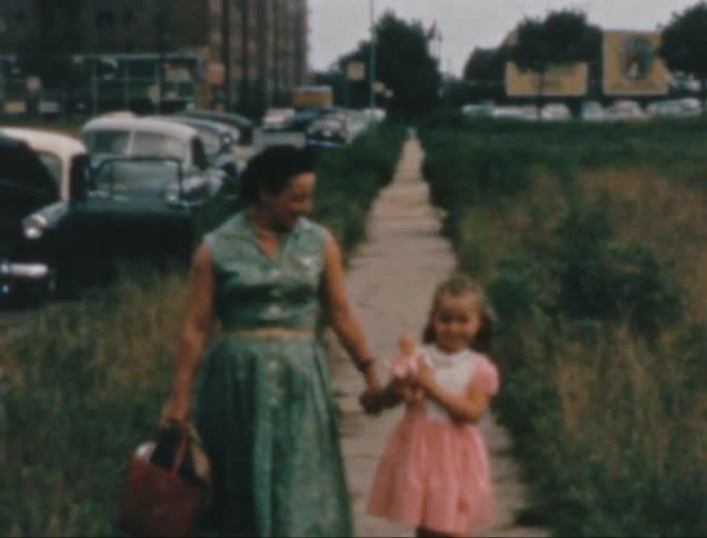 A clip of a mother and daughter walking on a narrow path