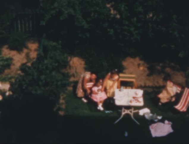 Out of focus shot on film of a family sitting on a green garden