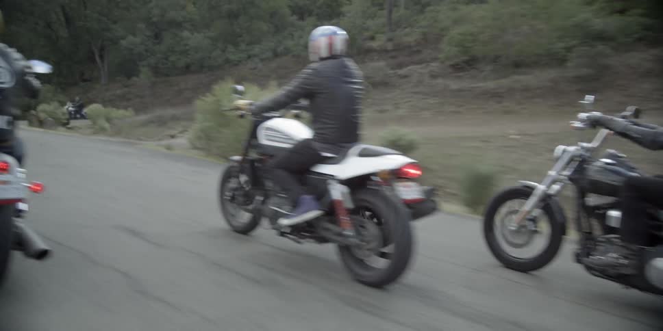Motorcyclists riding down a paved road