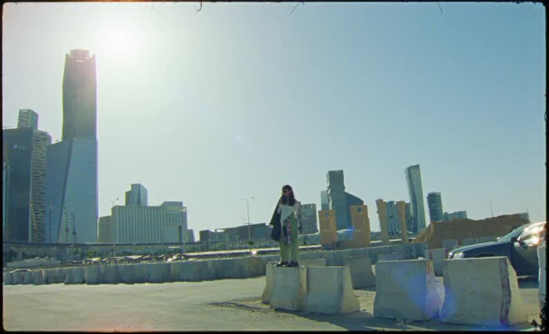A person is standing on a slab before a big city