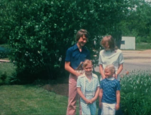 Siblings are standing together in the grass