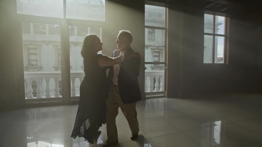 A male and female couple dancing in a room