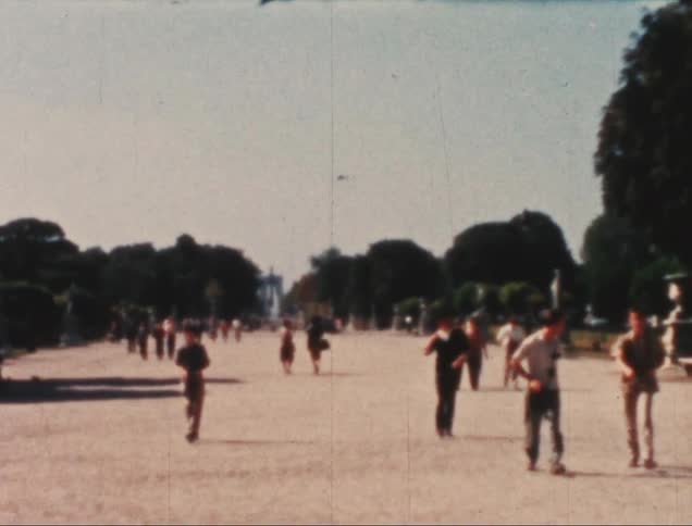 A group of people walking on pavement towards a camera