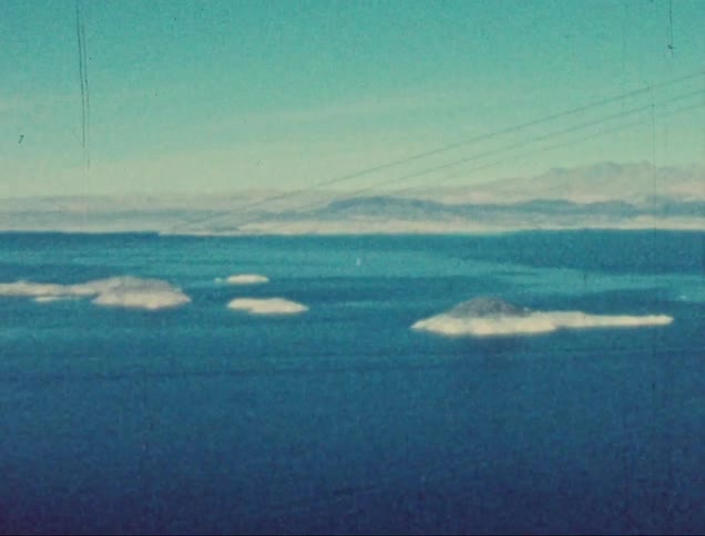 A huge blue lake with some islets in the middle and a coast with some mountains