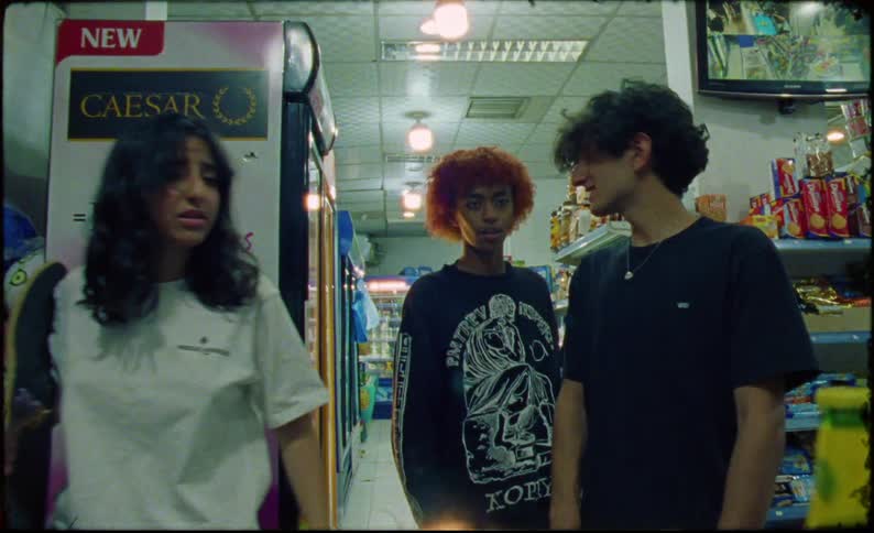 Teenagers in a supermarket picking up energy drinks and beverages