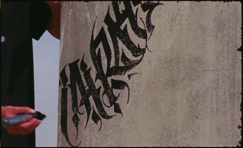 A man drawing graffiti with a marker on a wall