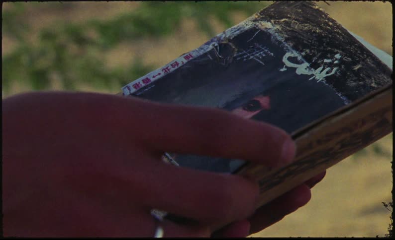 A vintage book or journal with arabic text is being flipped through