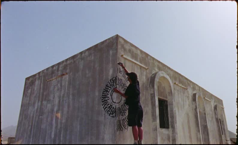 Man making an artistic painting on an old building