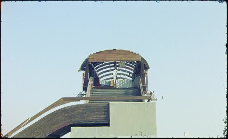 View of a cabin at the top and a white dress hanging down moving with the force of the air