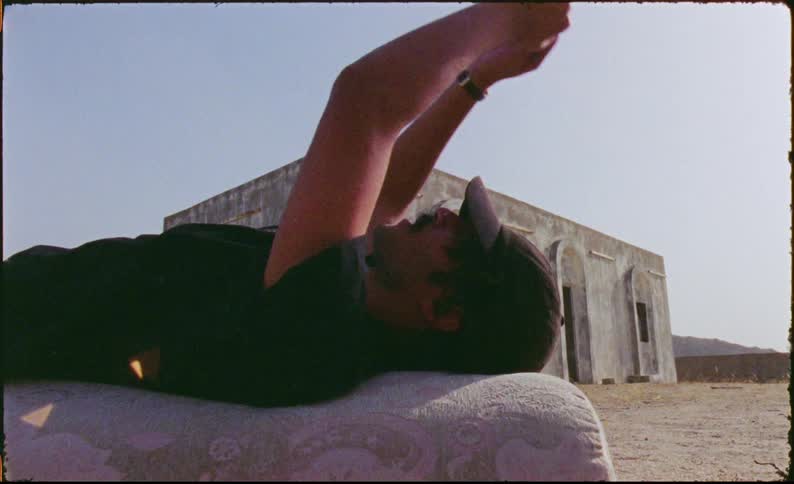 Man lying on a mattress in an outdoor area