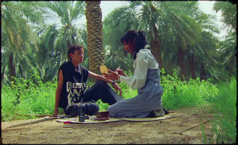 Woman applying makeup to another man in a rainforest