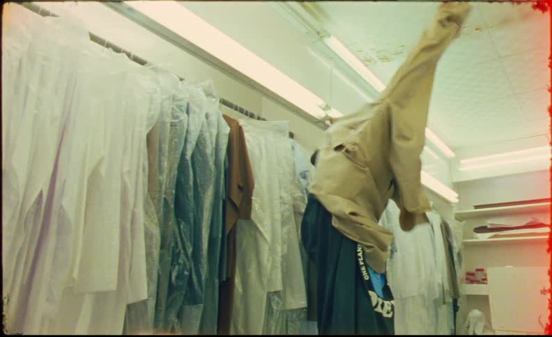 Man in a store trying on a long beige garment