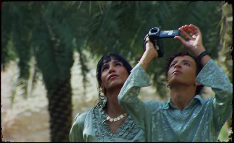 A man is filming the sky with a camcorder