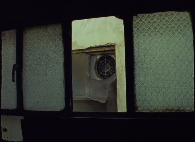 An air conditioning exhaust fan fixed to a wall seen from an open window